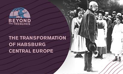 Black and white photo of an older white man with large white muttonchops standing in front of a crowd of people