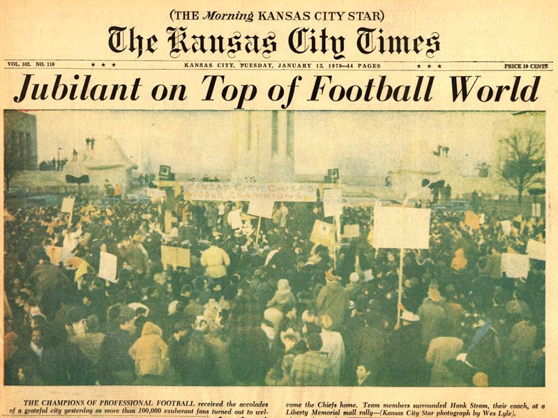 Scan de la première page du Kansas City Times. Titre&nbsp;: Jubilant au sommet du monde du football. Photographie : Grande foule rassemblée dans la zone à l'extérieur du Liberty Memorial. Beaucoup tiennent des pancartes.