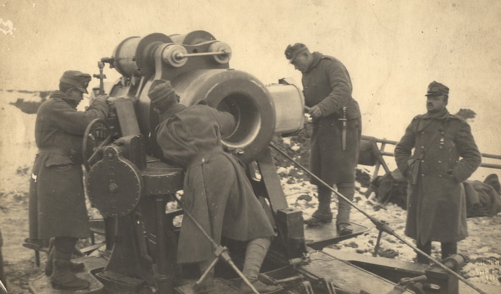 Des soldats se sont rassemblés autour d'un gros canon de mortier dans un champ enneigé. 