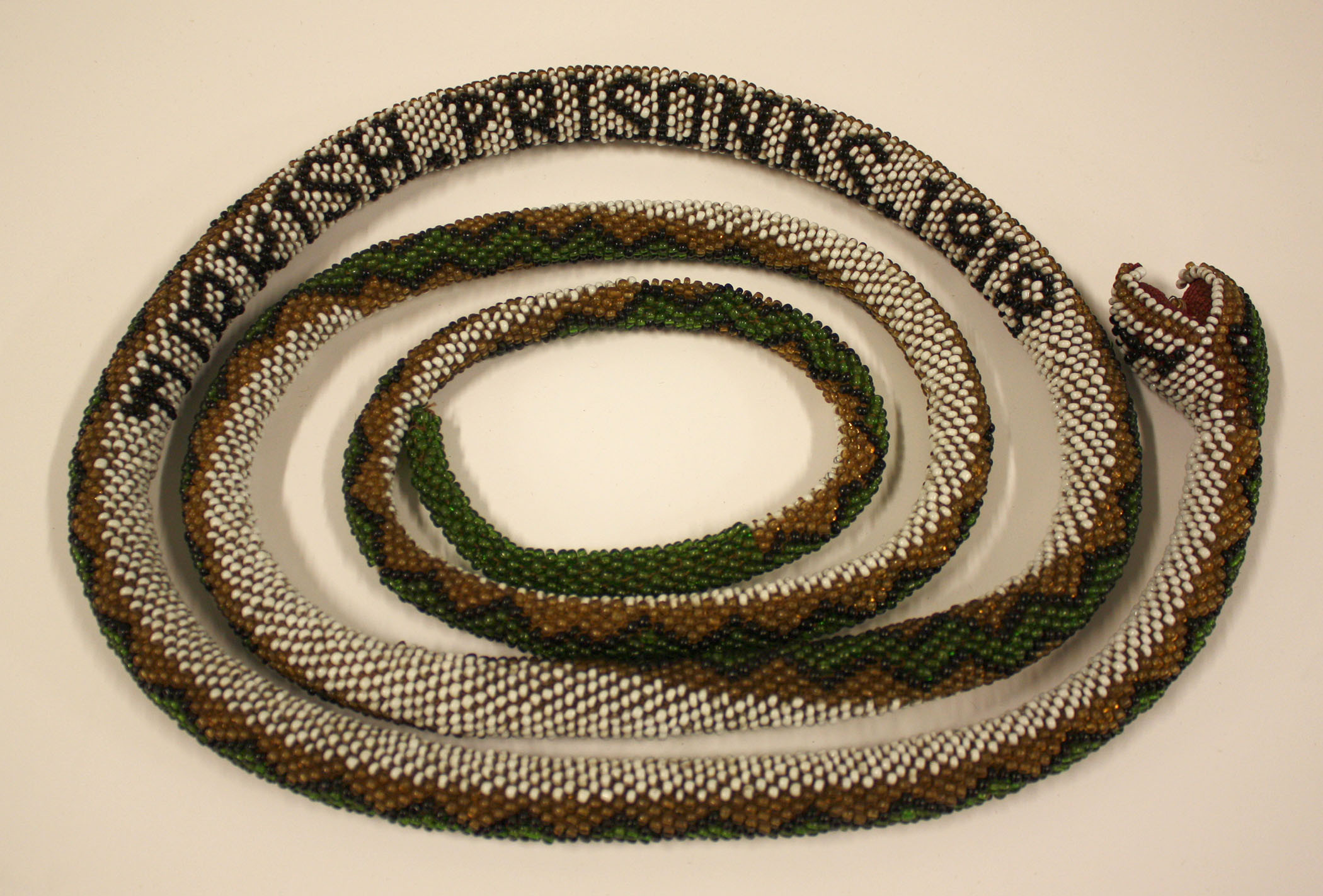 Photographie d'un serpent en tissu perlé
