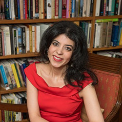 لقطة رأس لامرأة بنية فاتحة بشعر أسود متوسط ​​الطول ترتدي قميصًا أحمر