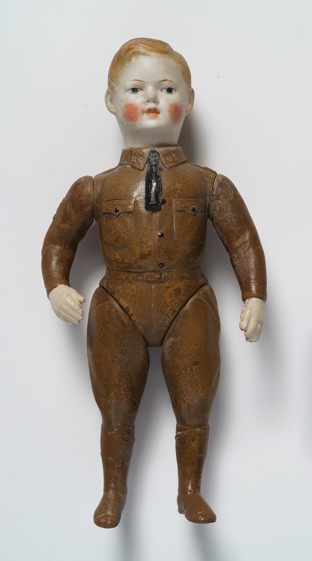 Photographie moderne d'une poupée articulée peinte pour ressembler à un enfant blond portant un uniforme militaire