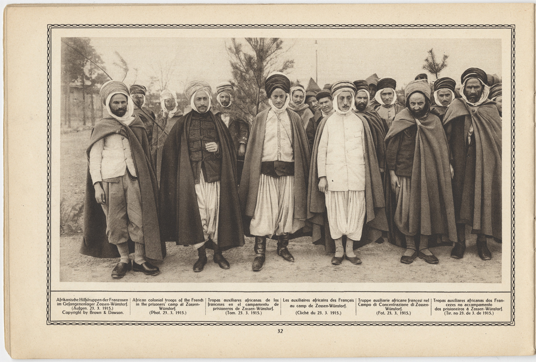 Scan d'une page de magazine vintage comportant une photographie en noir et blanc d'un grand groupe d'hommes musulmans vêtus de robes amples et de couvre-chefs posant pour un portrait de groupe debout. Les légendes en dessous sont rédigées en cinq langues.