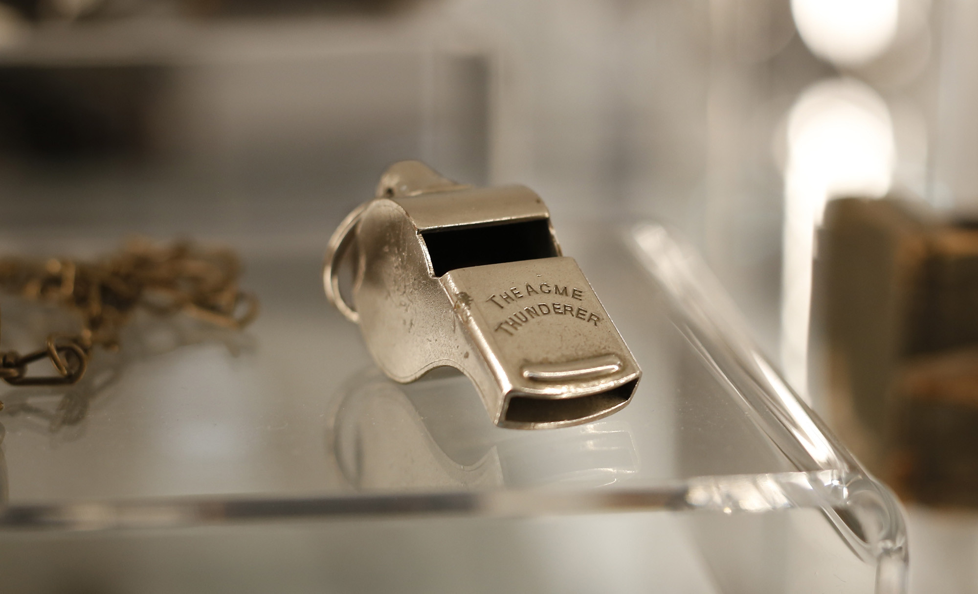 صفارة معدنية على شكل صفارة رياضية. محفور عليها عبارة "The ACME Thunderer"