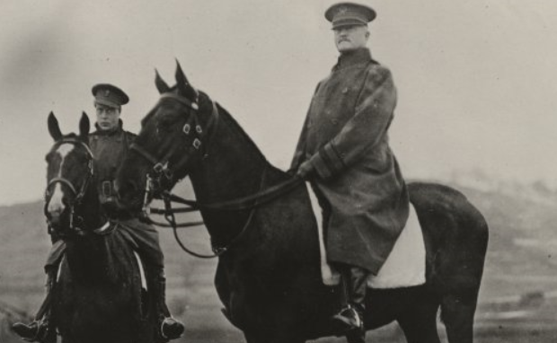 Photo en noir et blanc de deux hommes en uniforme d'hiver, coiffés de chapeaux et assis à cheval. L'homme au centre de l'image est le général Pershing.