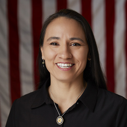 Black-haired, brown-skinned woman wearing a black collared shirt