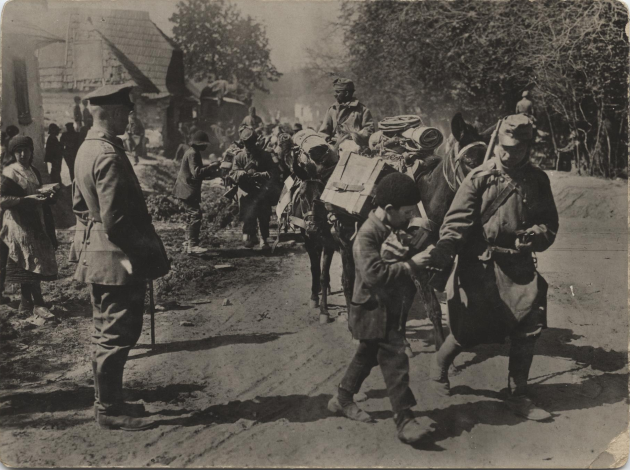 Photo en noir et blanc de soldats austro-hongrois défilant dans une rue.