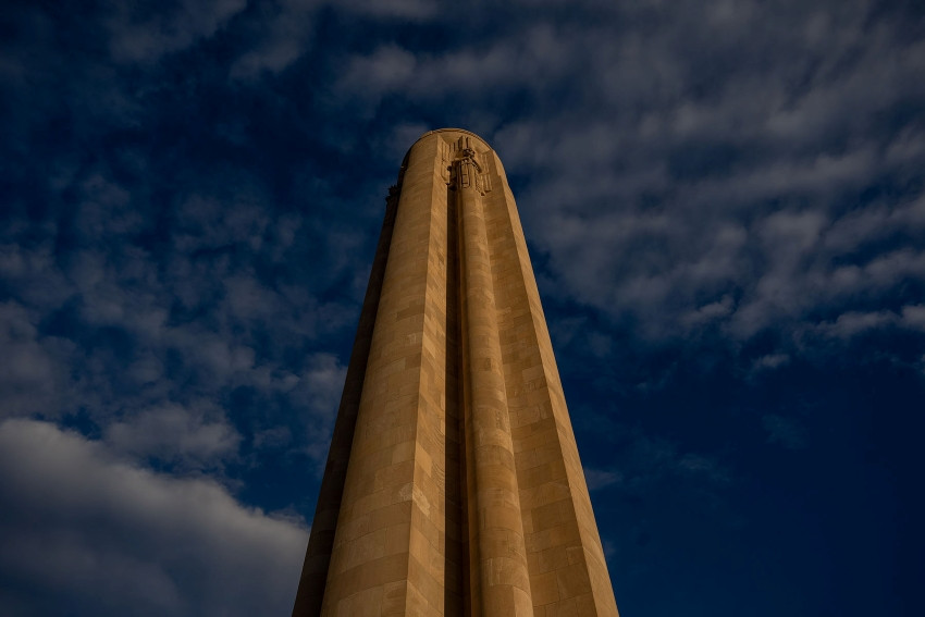 Photograph of the limestone tower taken from near the bottom, looking up, on a cloudy day.